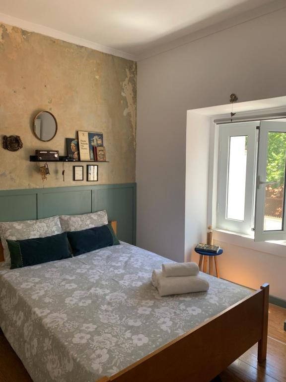Schlafzimmer mit einem Bett und einem Fenster in der Unterkunft Casa dos Poetas in Caldas da Rainha