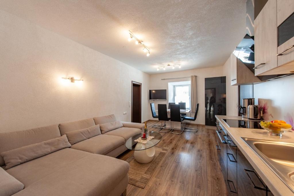 sala de estar con sofá y cocina en Appartement 103 en Bichlbach