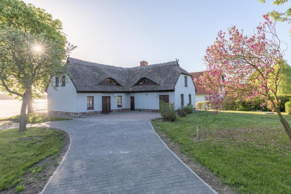 a white house with a driveway at Haus am See in Torgelow am See