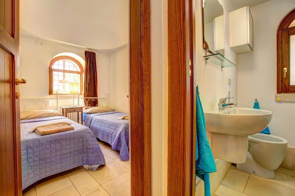 La salle de bains est pourvue de 2 lits et d'un lavabo. dans l'établissement Villa Trulli Carolina by Villa Plus, à Noci