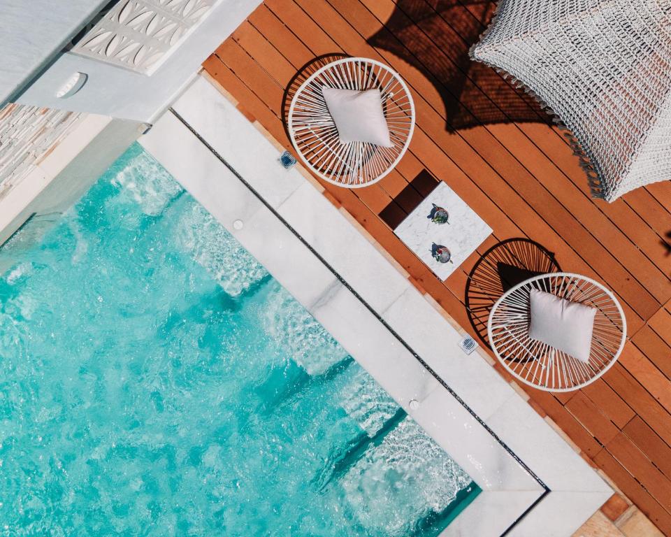 an overhead view of a swimming pool with chairs at Eliza Hotel by Panel Hospitality - Formerly Evdion Hotel in Nei Poroi