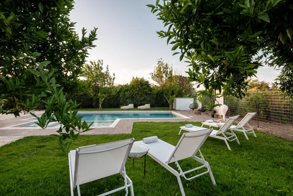 a yard with chairs and a swimming pool at Elenas Village House - Love apartment with Pool and Terrace in Alikianós