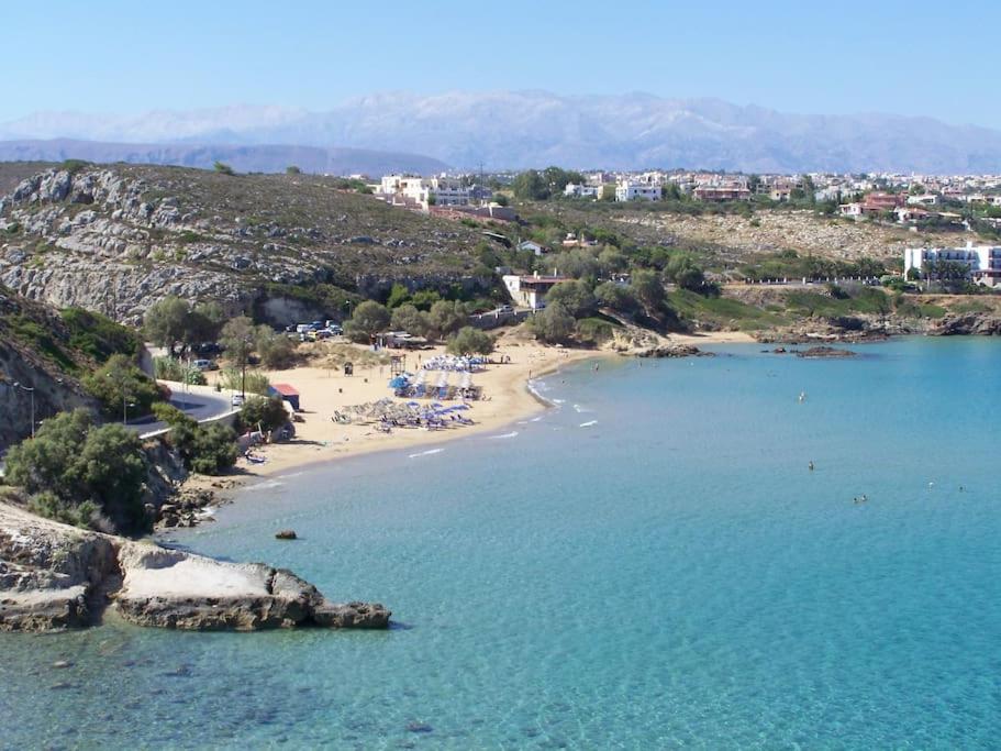 a beach with a group of people in the water at Manolo s olive farm, apartment with seaview in Chania Town