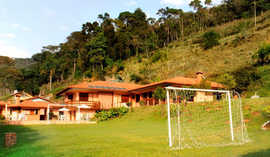 a house on a hill with a goal in the yard at Pousada Albuquerque in Teresópolis