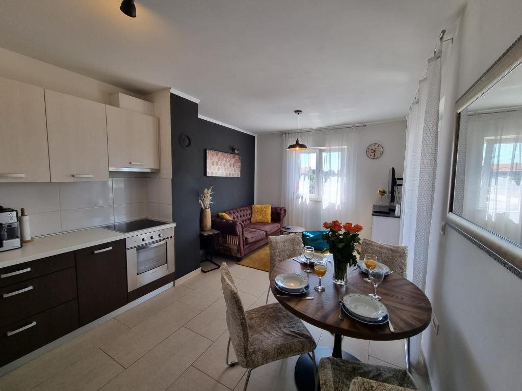 uma cozinha e uma sala de jantar com mesa e cadeiras em Apartman Marija em Biograd na Moru