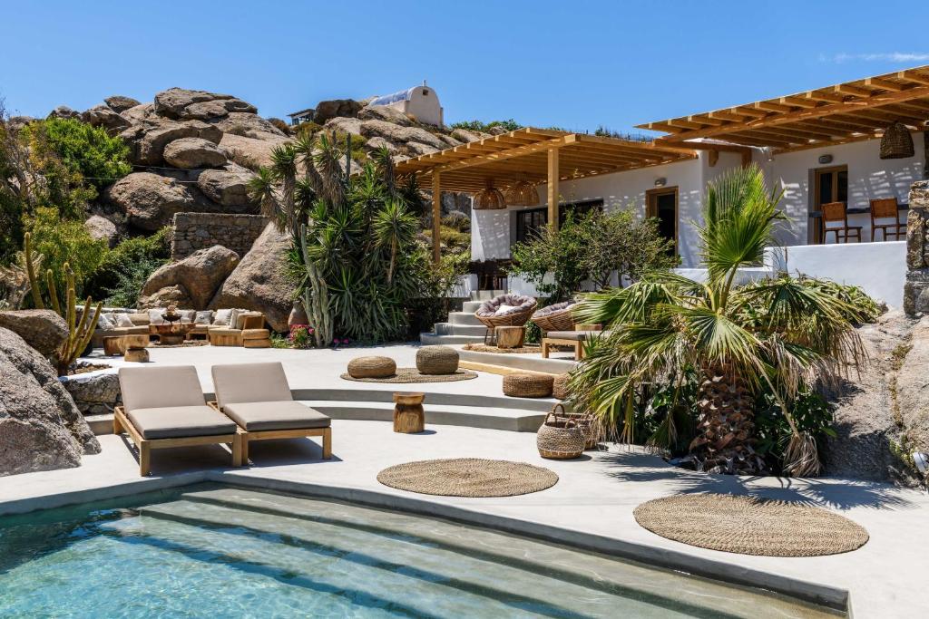 einen Hinterhof mit einem Pool und einem Haus in der Unterkunft ELEMENTS Mykonos Villa in Mykonos Stadt