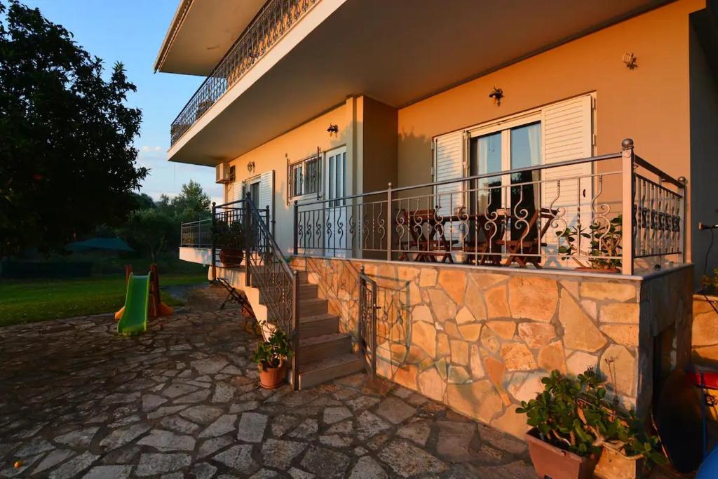a building with a balcony with a staircase on it at Siamos Villa in Vonitsa