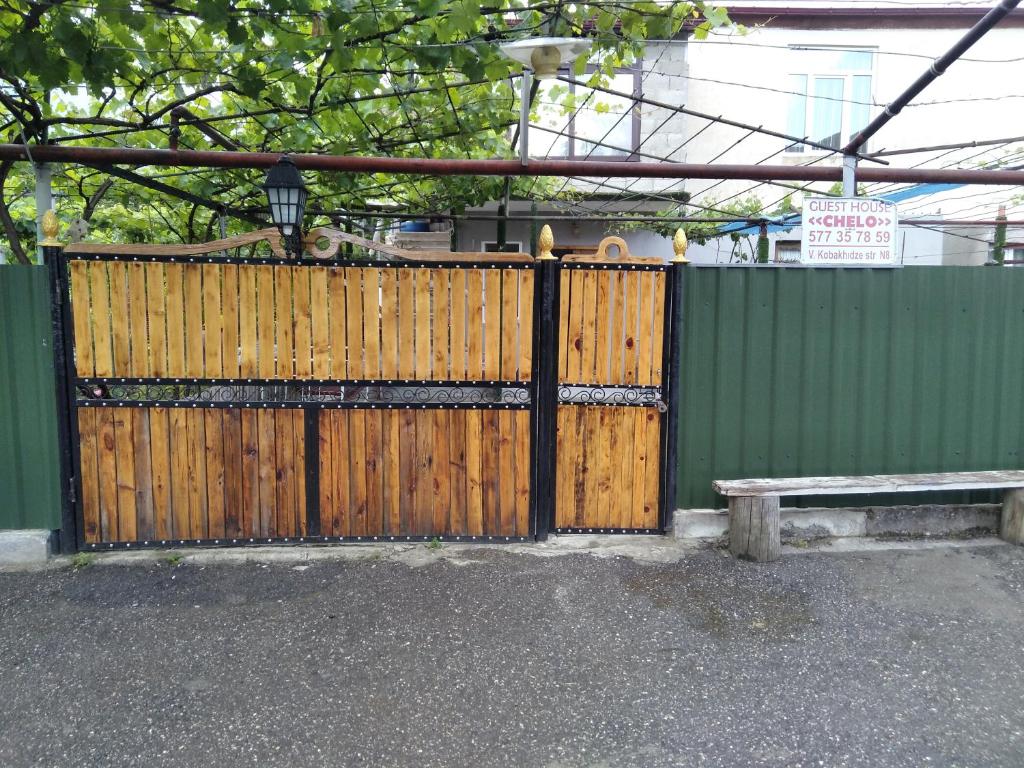 un cancello in legno con una panca di fronte a una recinzione di chelo ad Ambrolauri