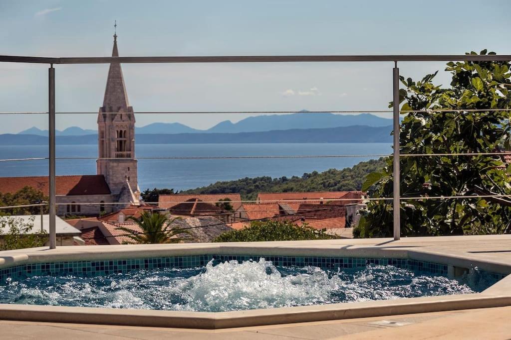 a swimming pool with a view of a church at Teo's place in Selca