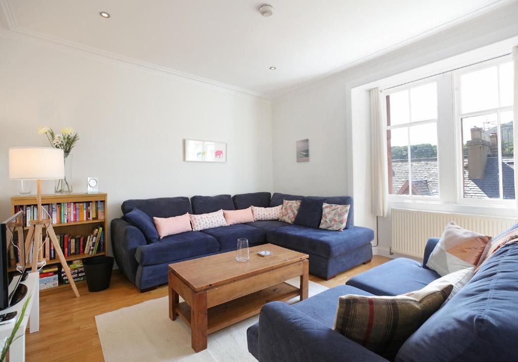 a living room with blue couches and a coffee table at Law View in North Berwick