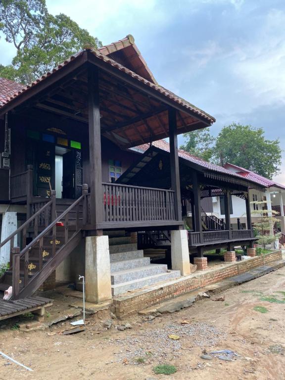 un edificio con porche y escaleras delante en Teratak Sekayu ( Room Stay ) en Kuala Kerau