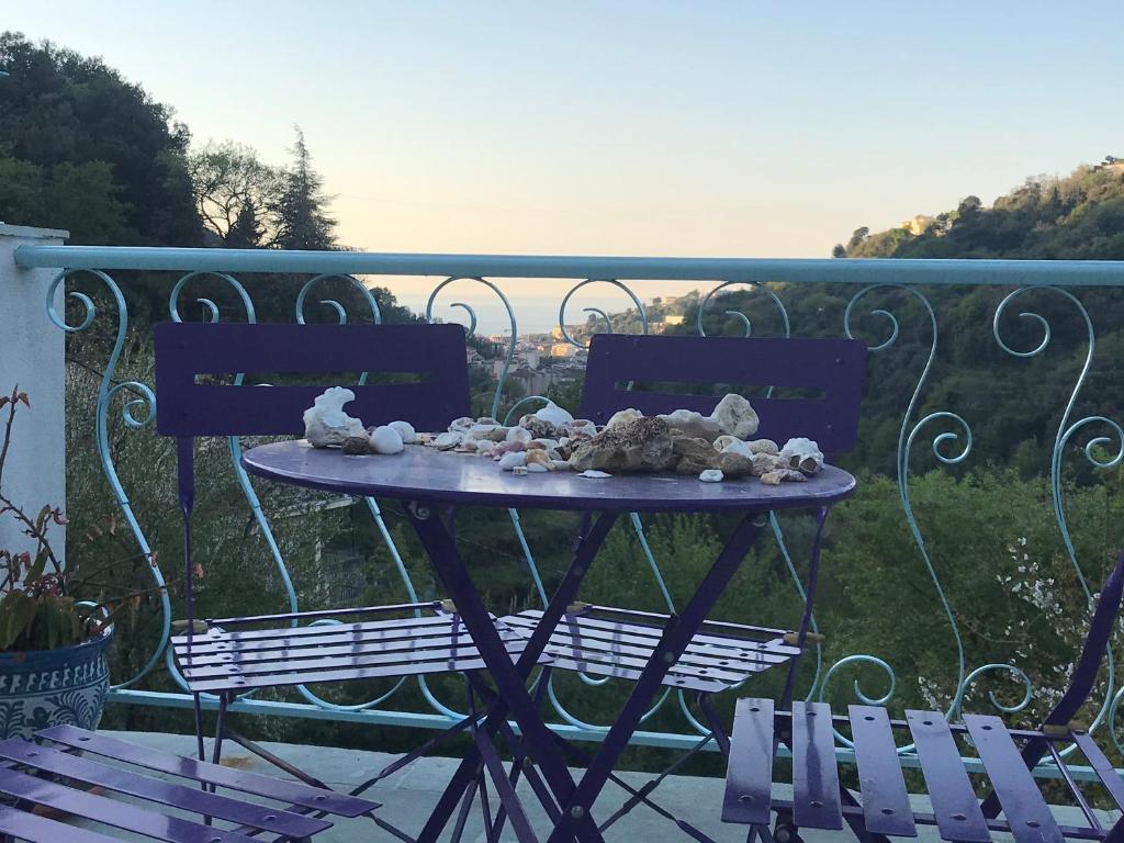 une table avec des animaux farcis sur un balcon avec deux chaises dans l'établissement Menton Mignon 2p bucolique vue mer campagne, à Menton