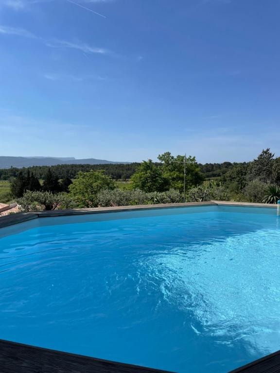une grande piscine bleue avec vue dans l'établissement Sainte Victoire le Cabanon, à Puyloubier