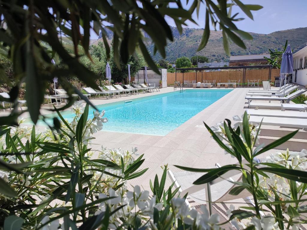 a swimming pool with lounge chairs and flowers at Inkantu B&B in Terrasini