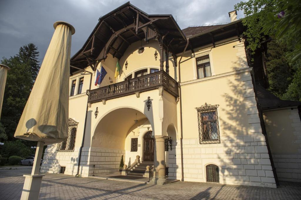 un gran edificio amarillo con una sombrilla grande en VILA HERBERSTEIN, en Velenje