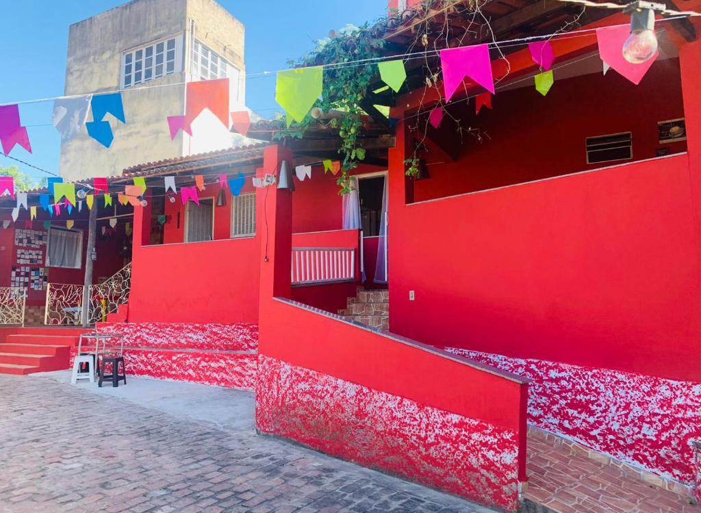 a red building with colorful flags on a street at Vila das Estrelas - Guesthouse in Lençóis