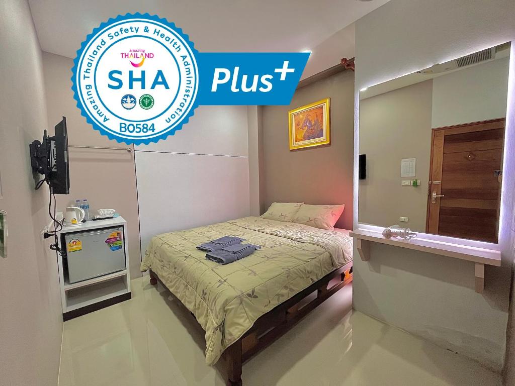 a small bedroom with a bed and a sign for a clinic at Variety winner hostel in Hat Yai