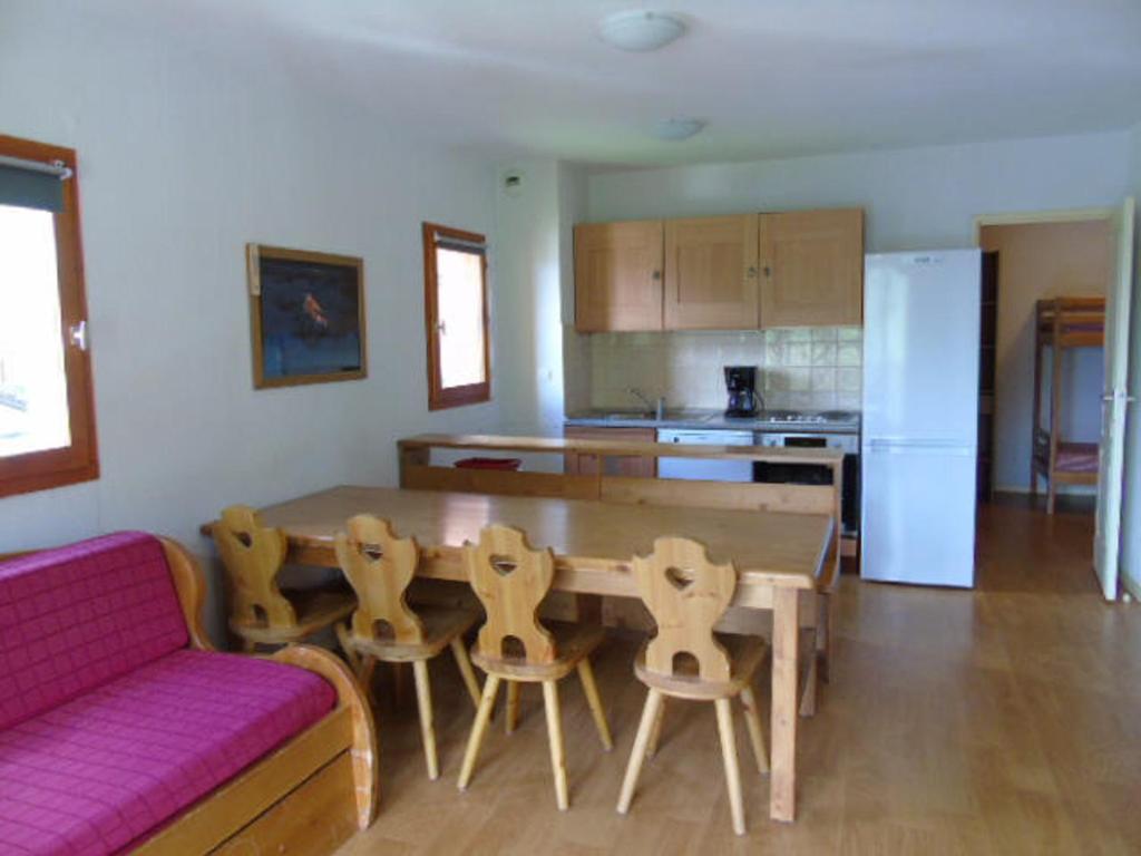sala de estar con mesa de madera y sofá en Appartement Valfréjus, 3 pièces, 8 personnes - FR-1-561-95, en Modane