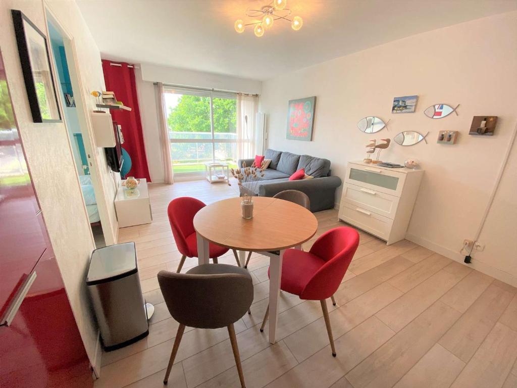 - un salon avec une table et des chaises rouges dans l'établissement Appartement Bénodet, 2 pièces, 2 personnes - FR-1-481-110, à Bénodet