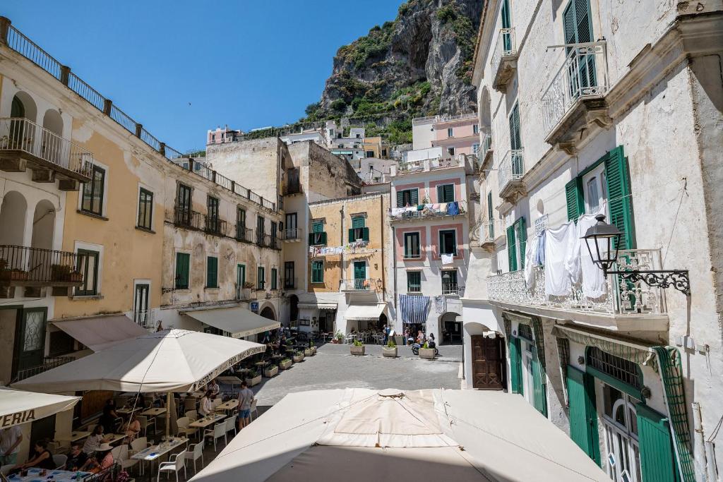 un vicolo con edifici e ombrelloni in una città di Casapà ad Atrani