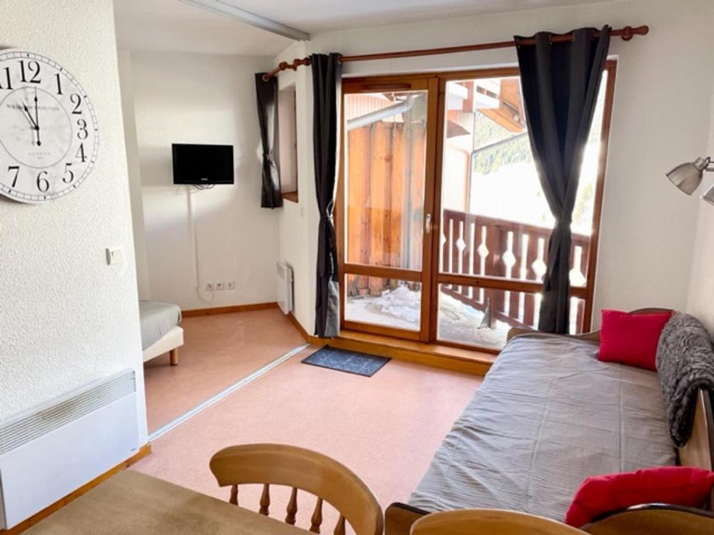 Appartement Saint-François-Longchamp, 3 pièces, 6 personnes - FR-1-635-73 في سانت فرانسوا-لونغشامب: غرفة معيشة مع ساعة على الحائط وطاولة