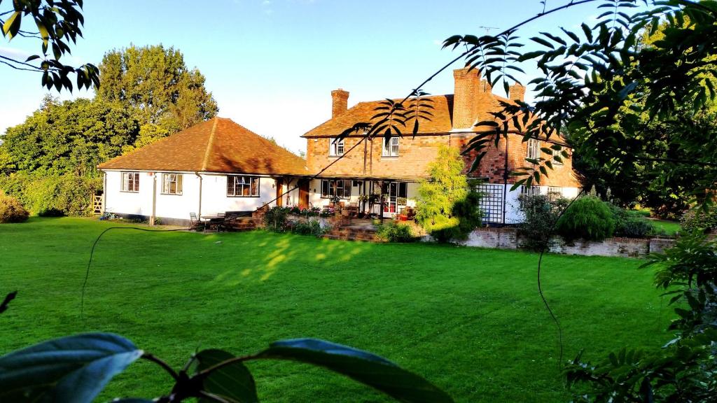una grande casa con un grande cortile verde di Iffin Farmhouse a Canterbury