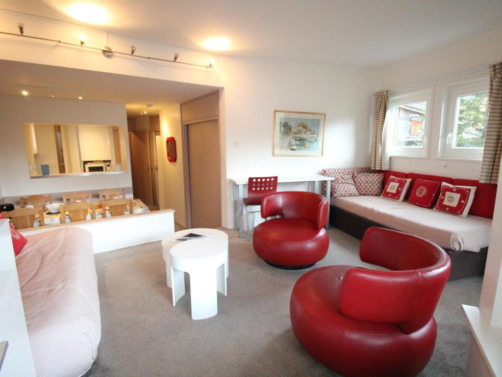 un salon avec des chaises rouges et un canapé dans l'établissement Avoriaz: Duplex ensoleillé, 2 chambres, 7 pers, balcon, TV, WiFi - FR-1-633-51, à Morzine