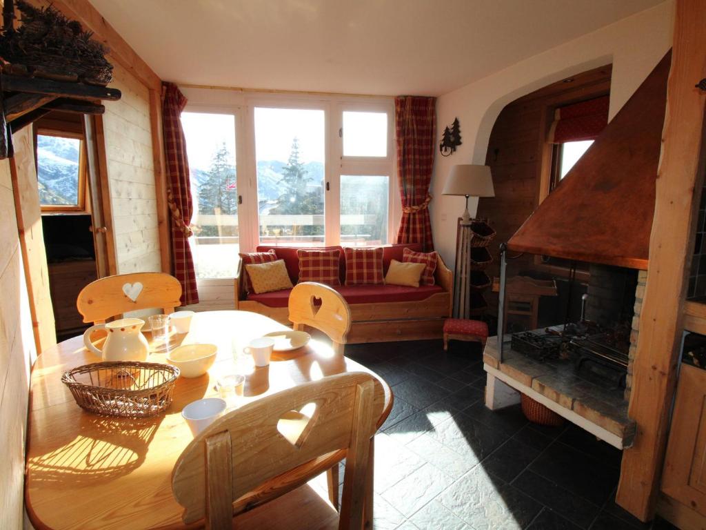 un salon avec une table et une cheminée dans l'établissement Appartement ensoleillé à Avoriaz, 4 pers, avec cheminée, wifi et skis - FR-1-633-54, à Morzine