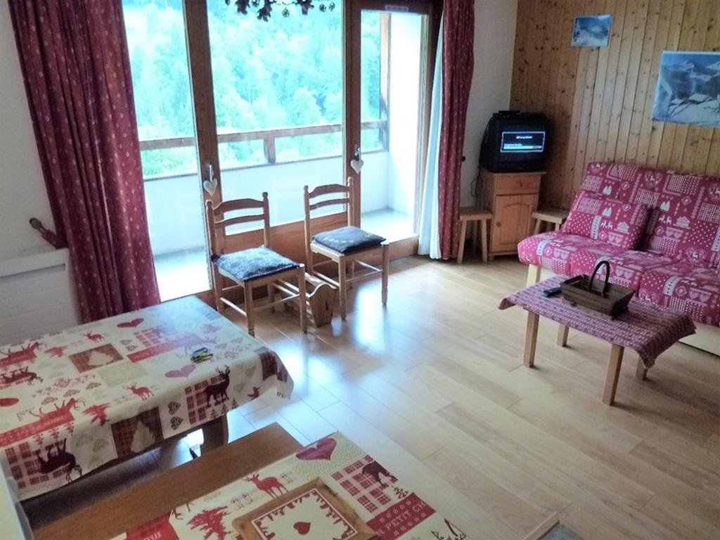 een woonkamer met een bank en stoelen en een tv bij Appartement Saint-Jean-d'Aulps, 1 pièce, 4 personnes - FR-1-573-88 in Saint-Jean-dʼAulps