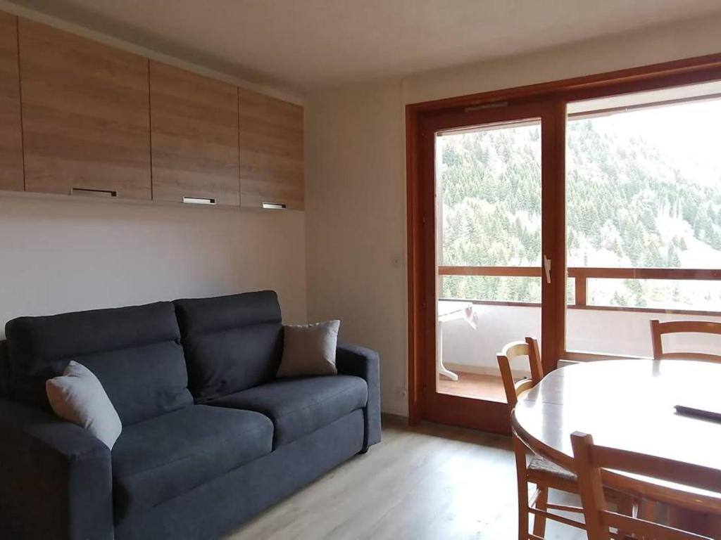 salon z niebieską kanapą i stołem w obiekcie Studio chaleureux proche des pistes avec piscine et parking - FR-1-573-89 w mieście Saint-Jean-dʼAulps