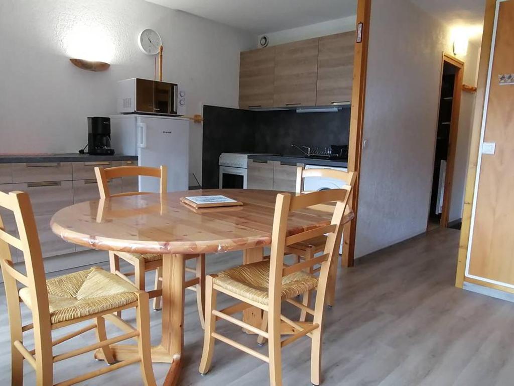 een eettafel met stoelen en een keuken bij Appartement Saint-Jean-d'Aulps, 1 pièce, 5 personnes - FR-1-573-89 in Saint-Jean-dʼAulps