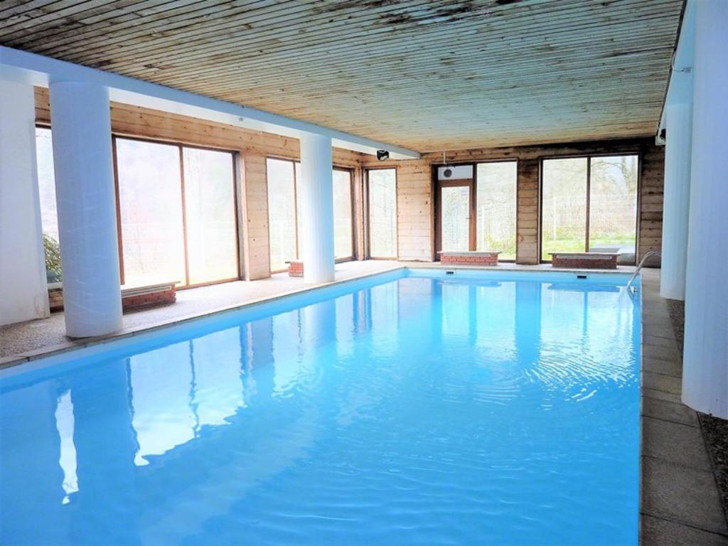 duży basen z błękitną wodą w budynku w obiekcie Studio chaleureux proche des pistes avec piscine et parking - FR-1-573-89 w mieście Saint-Jean-dʼAulps