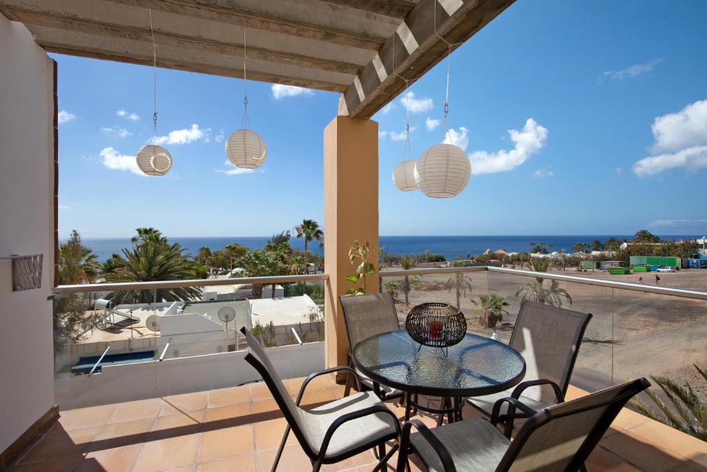 a table and chairs on a balcony with a view of the ocean at Apartamento Relax and Dream in Pájara