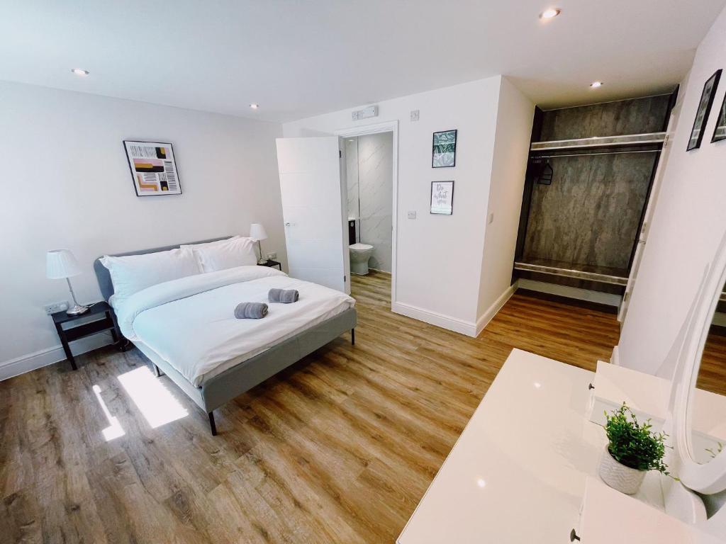 a bedroom with a bed and a wooden floor at Prosper House Apartment 4 in Norwich