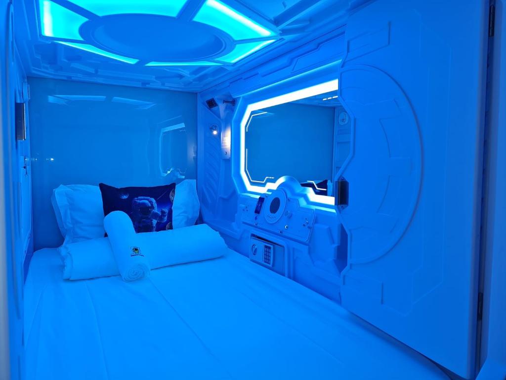 Cette chambre bleue comprend un lit dans un rv. dans l'établissement Galaxy Pods Capsule Hotel Boat Quay, à Singapour
