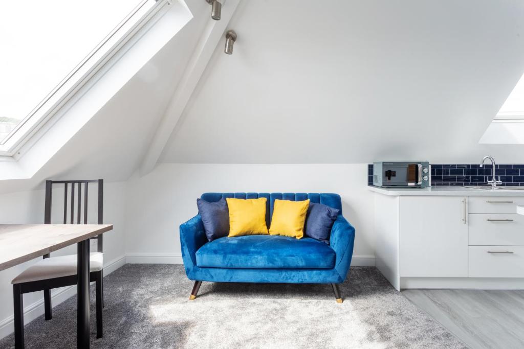 een blauwe stoel met gele kussens in een keuken bij Beach Loft Luxury Flat in Lyme Regis