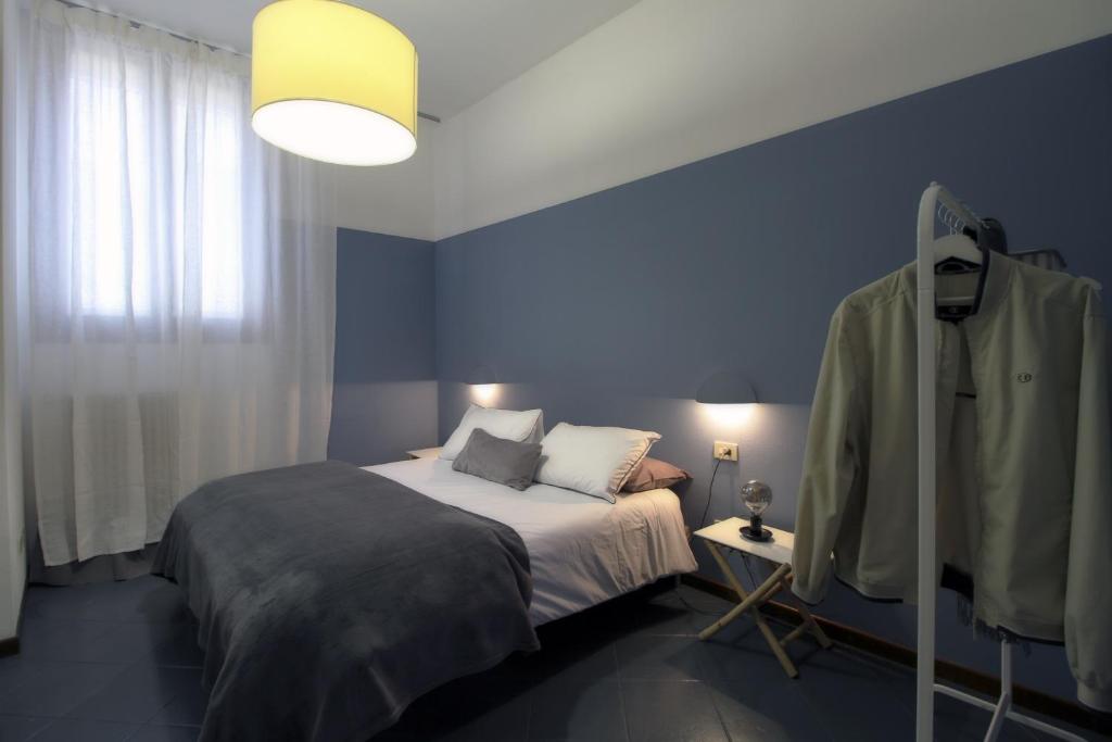 een slaapkamer met een bed en een blauwe muur bij Appartamento lungo il Sentiero del Viandante Lecco in Lecco