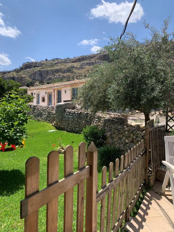 una valla de madera frente a un patio con una casa en Masseria Santacatrini, en Melilli