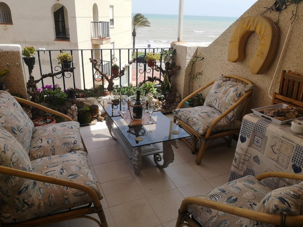 un balcón con sillas y una mesa y la playa en En Marina D'Or primera linea real, en Oropesa del Mar