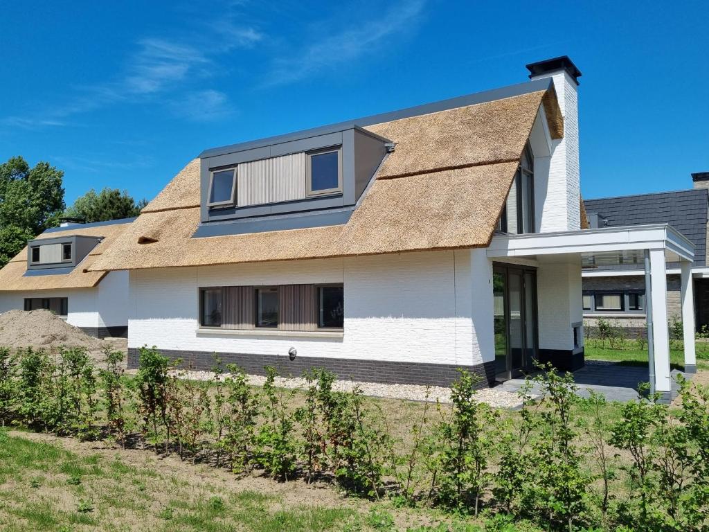 Biały dom z brązowym dachem w obiekcie Duyndomein Noordwijk w mieście Noordwijk
