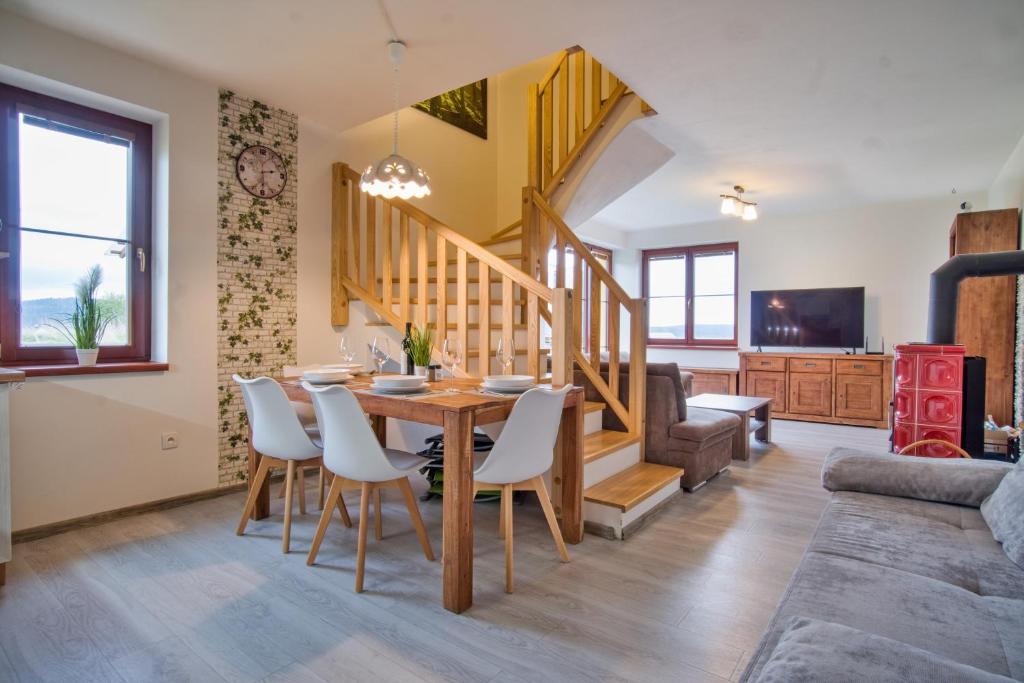uma sala de jantar e sala de estar com mesa e cadeiras em Rezidence Podkova em Frymburk