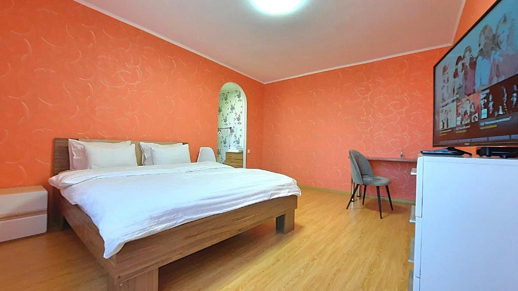 a bedroom with a bed with an orange wall at Червоне і біле Мережа квартир Alex Apartments Документи для відряджень Безконтактне заселення 24-7 in Poltava