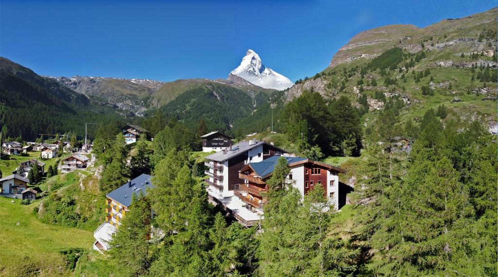 a village in the mountains with a snow covered mountain at Appartements Zermatt Paradies in Zermatt