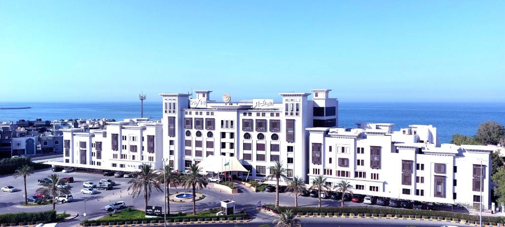 een groot wit gebouw voor de oceaan bij Safir Fintas Hotel Kuwait in Koeweit