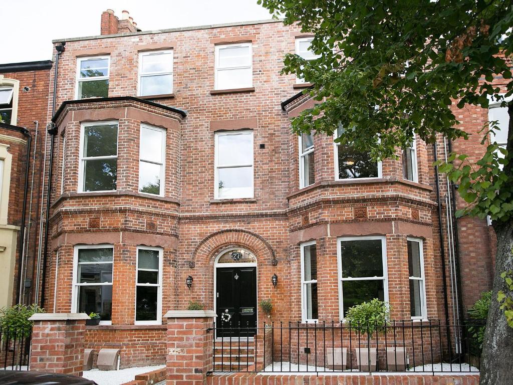 un edificio di mattoni rossi con una porta nera di CityGo Apartments Queens Wellington a Belfast