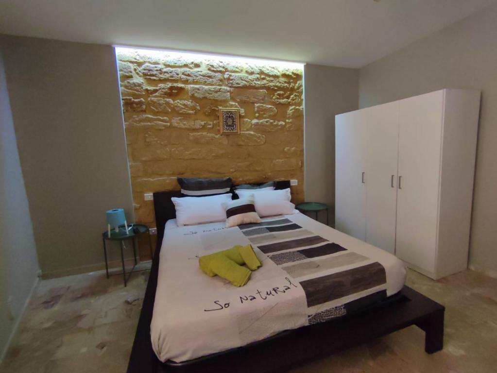 ein Schlafzimmer mit einem Bett und einem gelben Handtuch darauf in der Unterkunft Le case di Grazia in Ioppolo Giancaxio