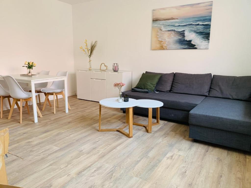 a living room with a blue couch and a table at FEDDERSEN LIVING Kernsanierte Ferienwohnungen - Gemütlich - Netflix - Voll ausgestattet - zentral in Brunsbüttel