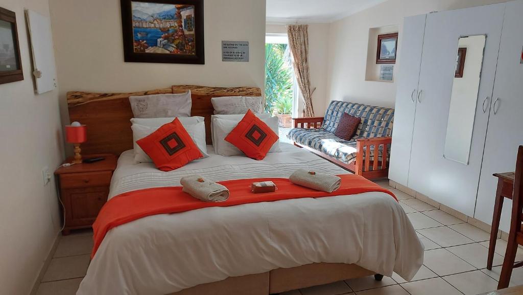 1 dormitorio con 1 cama grande con almohadas rojas en Bethel B&B / Selfcatering, en George