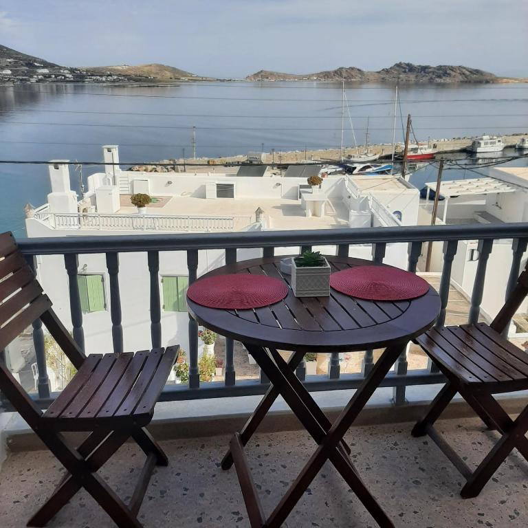 a table and chairs on a balcony with a view of the water at Flora Rooms & Apartments in Naousa