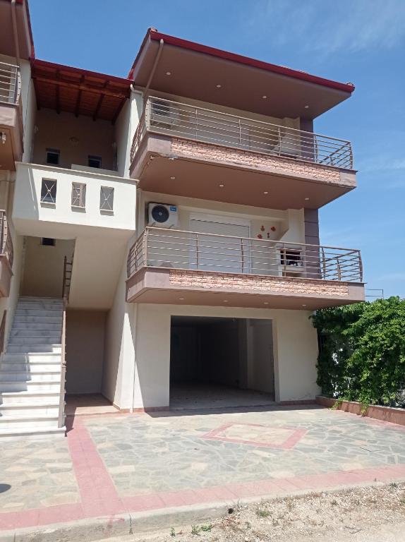 una casa con balcón y escaleras delante en Deluxe Apartments 1, en Orfánion